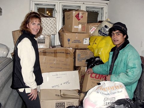 Suzanne Fenlason sorting donated winter clothes, November 2001. The box in front is marked “John & Susie”