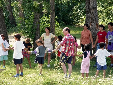 John Fenlason (in the patterned shirt) joins a circle game with the children and the team in the early years