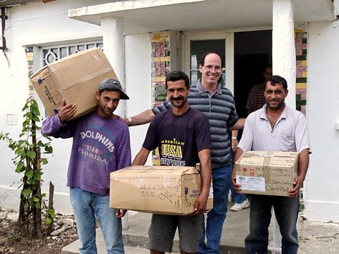 John Fenlason (in the striped shirt) with friends in Lazareni, unloading donated clothes and supplies in the early years