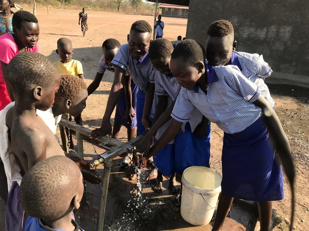 Students at the bore-well water pump at Timothy School